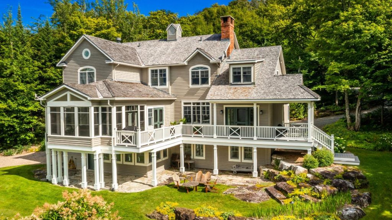 Majestueuse demeure de style Nouvelle-Angleterre invitant à la sérénité sur son paisible terrain boisé bordant un lac