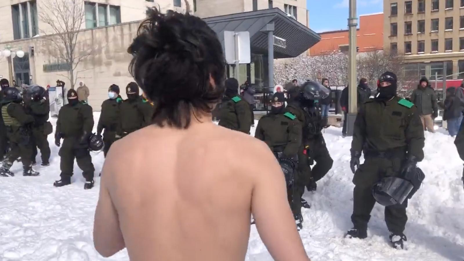 Un manifestant danse torse nu devant les policiers à Ottawa