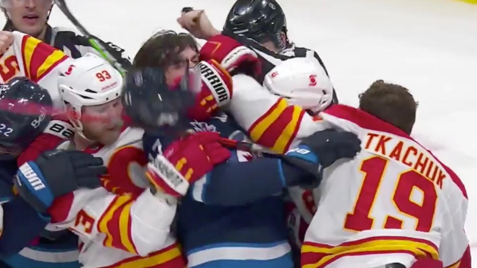 Flames’ Bennett holds Jets’ Lowry while Tkachuk throws some punches